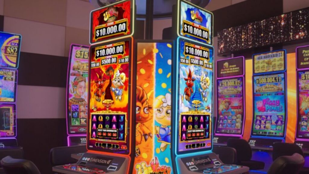 A vibrant shot of a casino floor featuring several modern, brightly lit slot machines. The central machine displays a colorful "Wooly" themed game with characters and jackpot amounts, set against a backdrop of purple and blue ambient lighting.