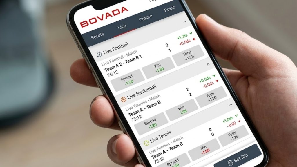 A close-up of a bettor scrolling through live football and basketball betting lines on the mobile interface, highlighting features often analyzed in Bovada vs BetOnline reviews.