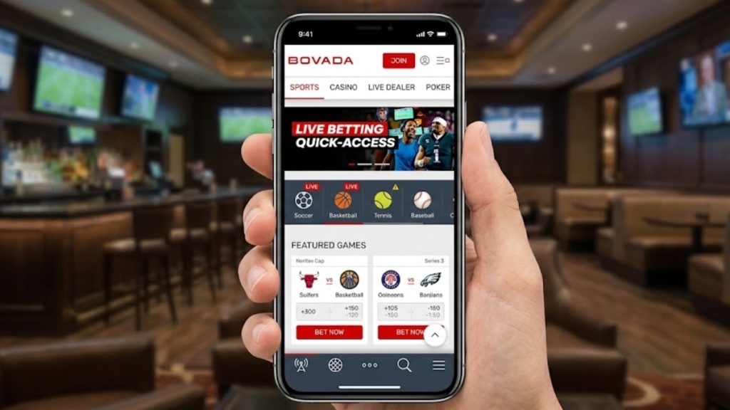 A close-up of a hand holding a smartphone displaying the Bovada mobile sports betting lobby with featured games, useful for a Bovada vs MyBookie review.